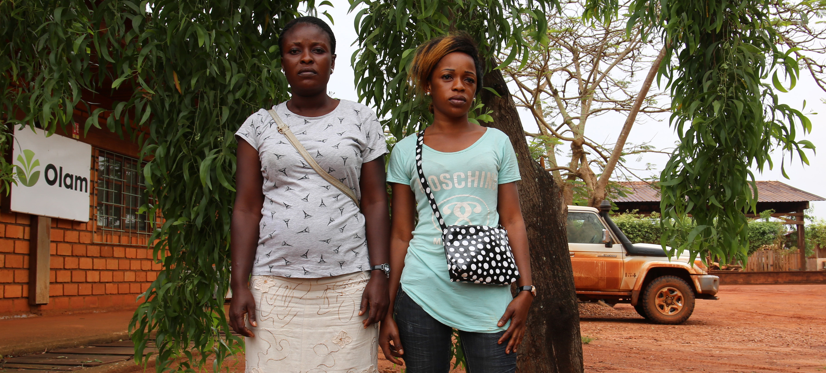 two women stand in front of olan sign in congo
